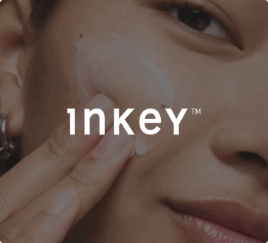 Persona que se está aplicando crema en la mejilla con el texto superpuesto «Inkey»
