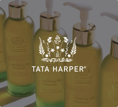 Flaconi di olio detergente nutriente Tata Harper con erogatore e logo floreale sovrapposto.