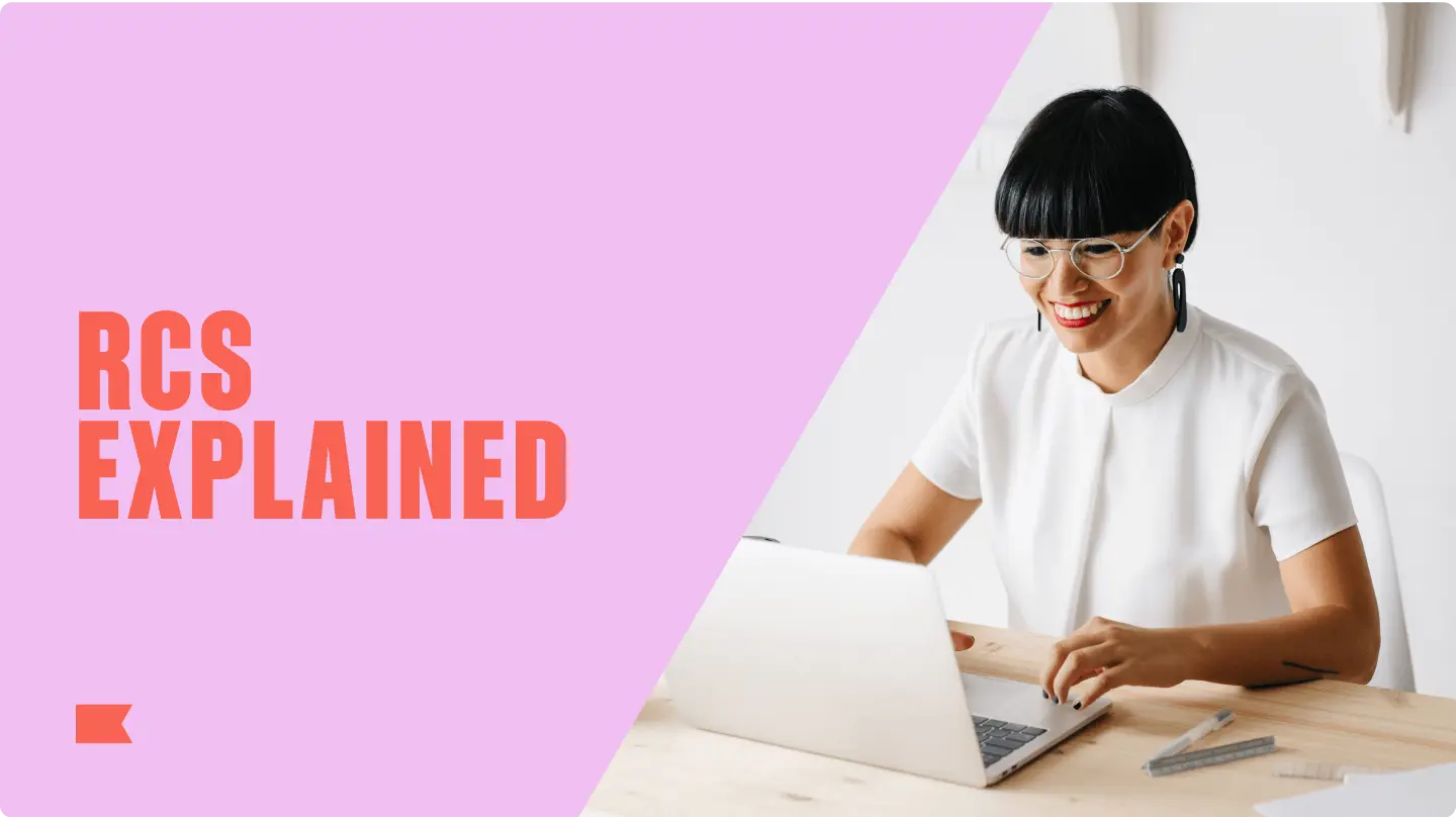 RCS Explained text with a smiling person using a laptop at a desk.