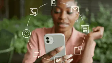 Woman using a smartphone with digital icons around her, representing communication and shopping apps.