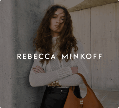 Woman with long hair in a lace top holding a brown handbag. Text overlay: "REBECCA MINKOFF.